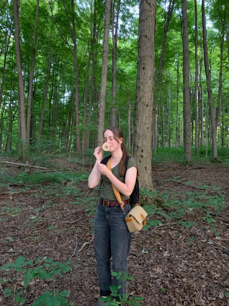 Sarah Culliton smells a mushroom she found in the woods.